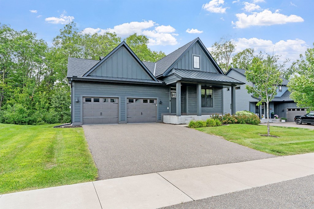 A two-story house with a garage on the first floor and a covered porch on the second floor.
