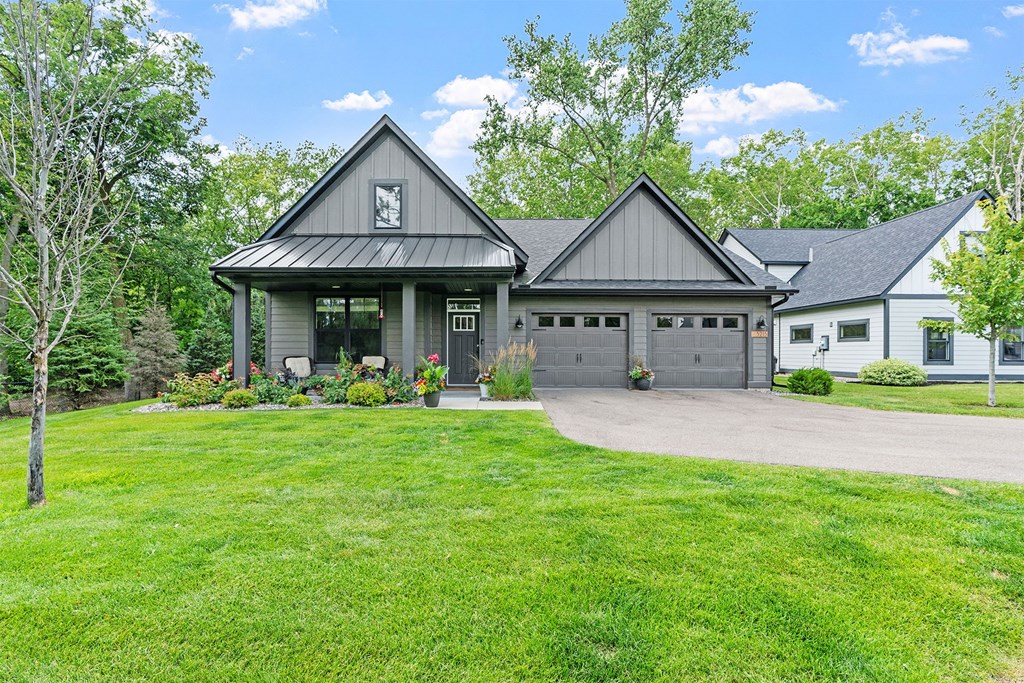 A house with a grey roof and a white garage door.