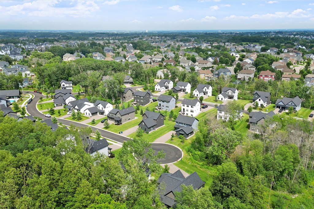 A bird's eye view of a residential area with houses surrounded by greenery.
