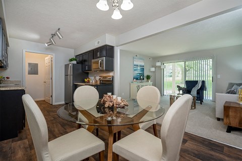 a living room and dining room with a glass table and chairs