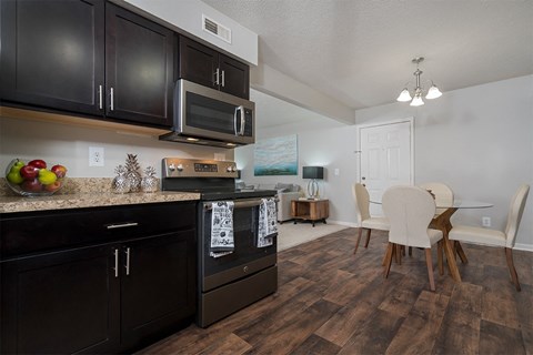 a kitchen and dining room with black cabinets and a table and chairs