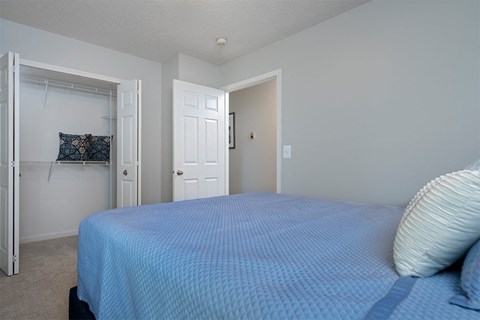a bedroom with a blue bed and a closet