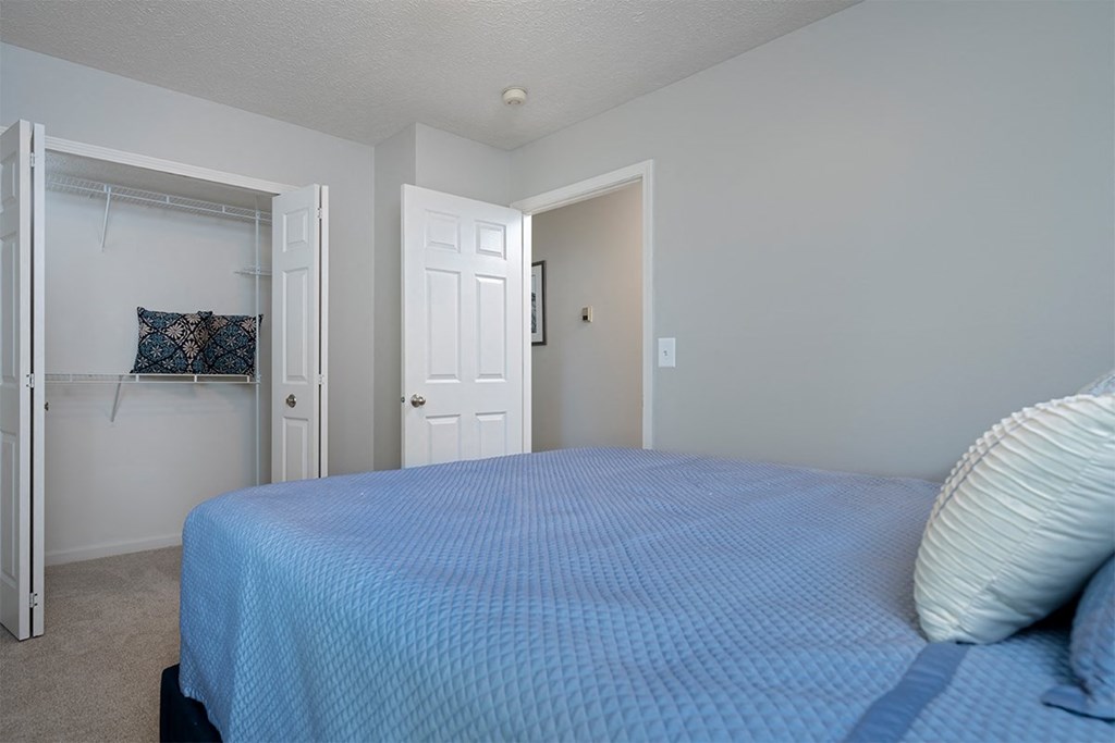 a bedroom with a blue bed and a closet