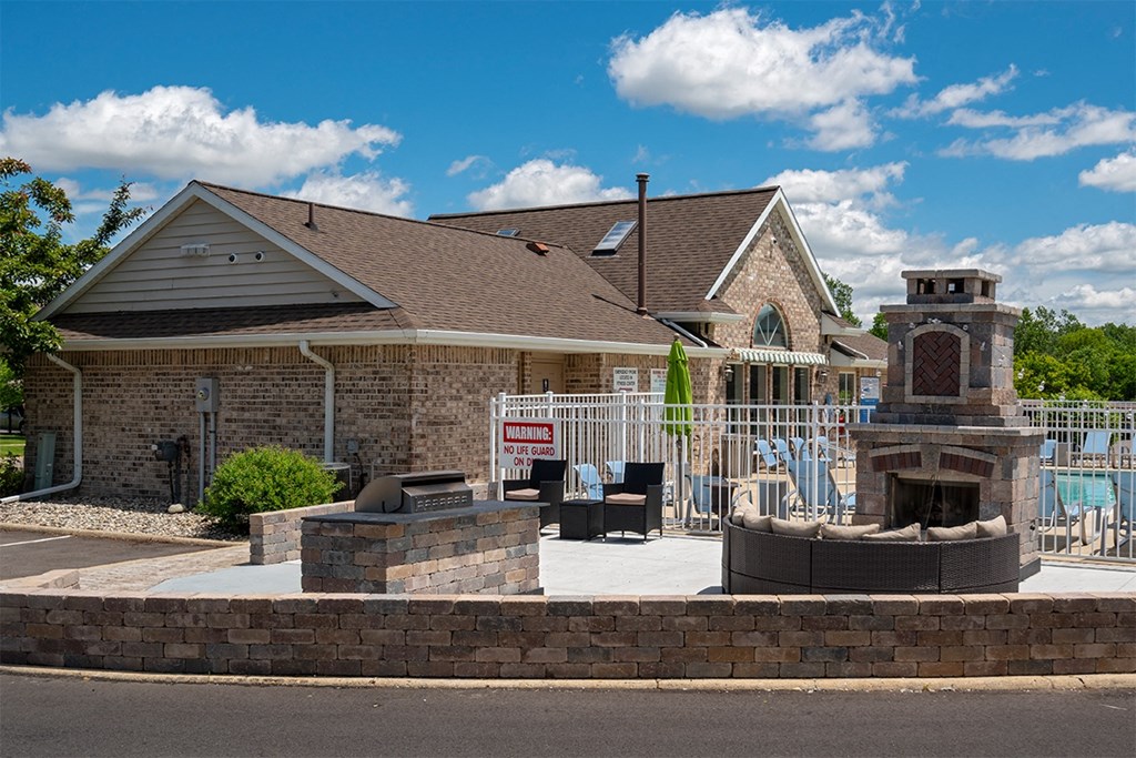outdoor grilling area with fireplace and sofa