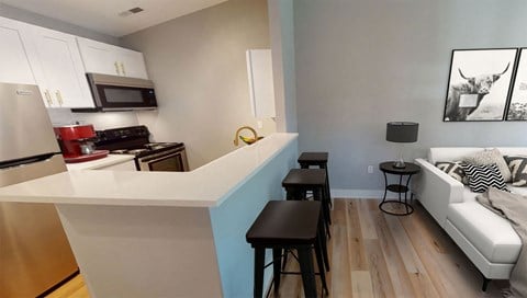 a kitchen with a bar and a living room with a couch