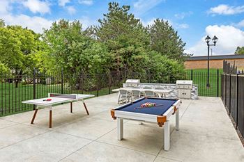 an outdoor patio with tables and ping pong tables and a pool table