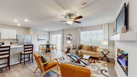 A living room with a ceiling fan and a television on the wall.