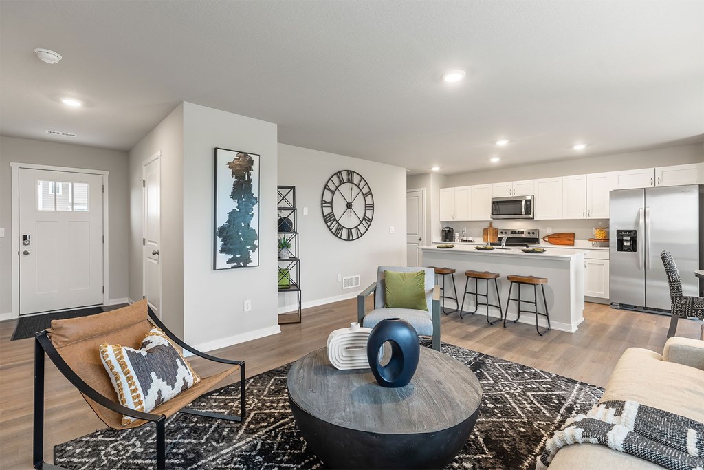 A modern living room with a large clock on the wall.
