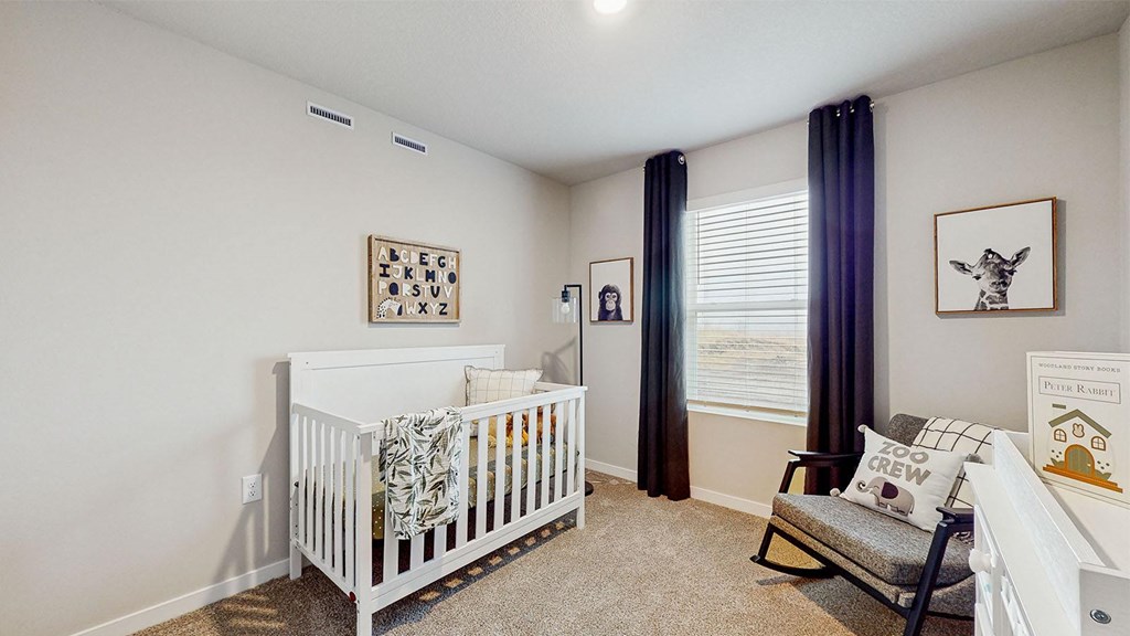 A white crib sits in a room with a framed picture of a giraffe on the wall.