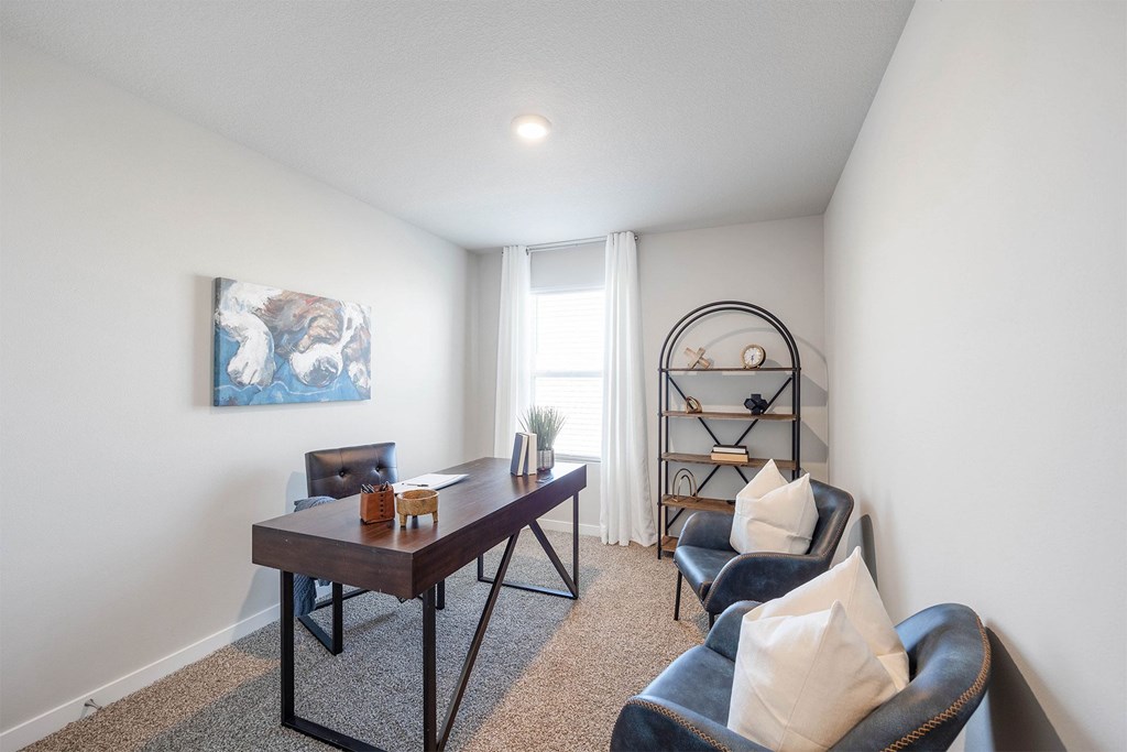 A room with a table, chairs and a painting on the wall.