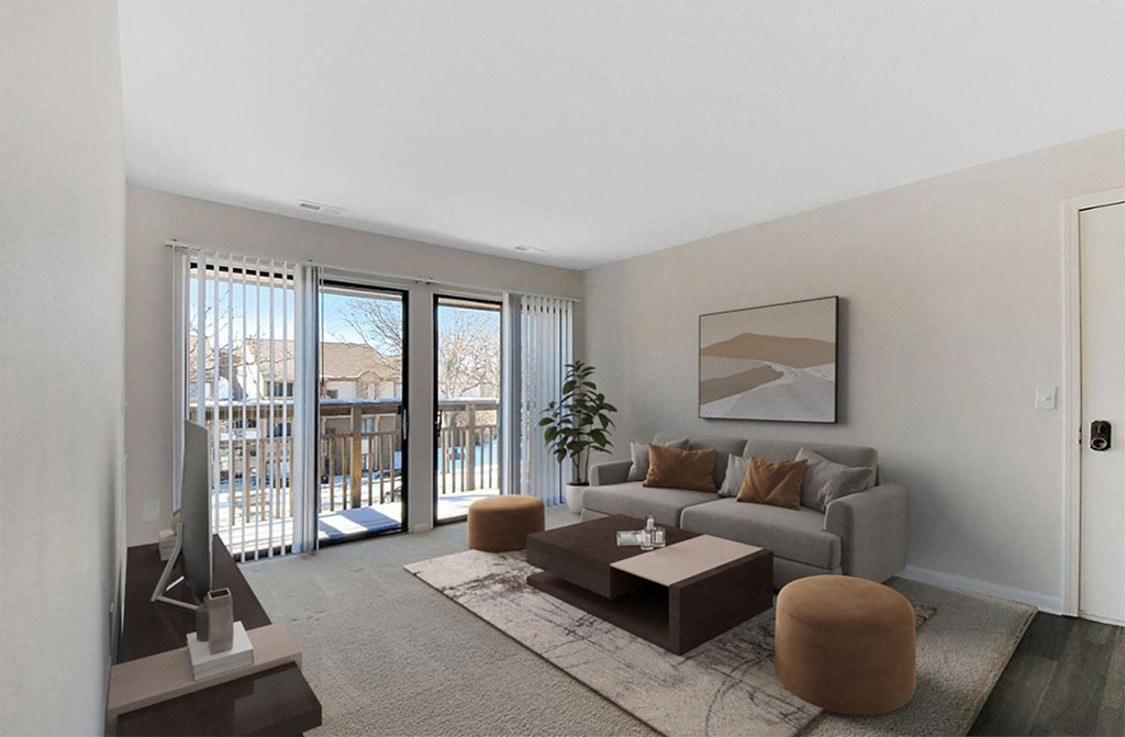 A living room with a grey couch, a brown ottoman, a coffee table, and a television.
