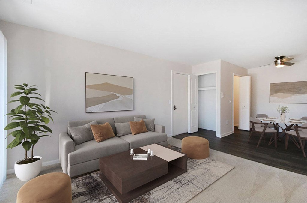 A living room with a grey couch, a brown coffee table, and a large painting on the wall.