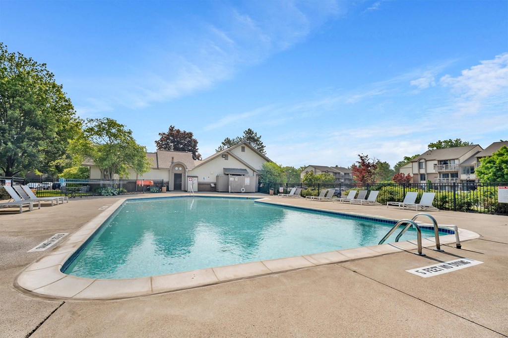 A large outdoor swimming pool with a slide and sun loungers.
