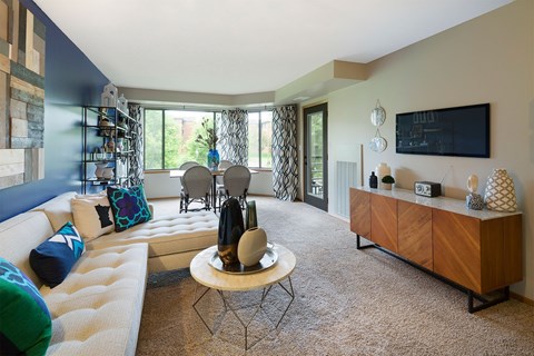 A living room with a white couch and a wooden cabinet.