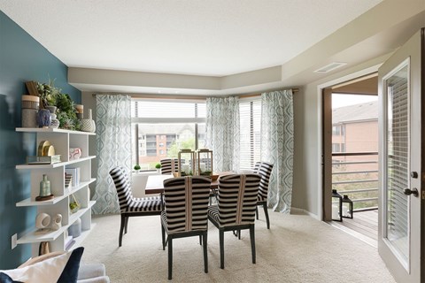 A dining room with a table and chairs.