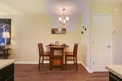 A dining room with a wooden table and chairs.