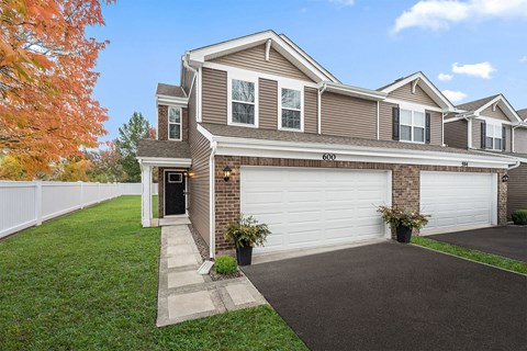 A house with a brown and white exterior and a garage door.