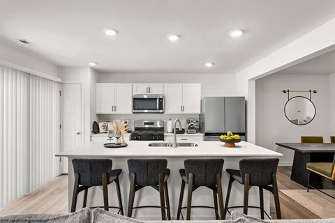 A modern kitchen with a dining table and chairs.