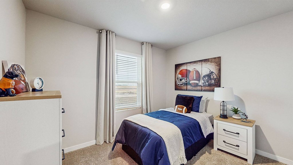 A bedroom with a bed, nightstand, and a painting on the wall.