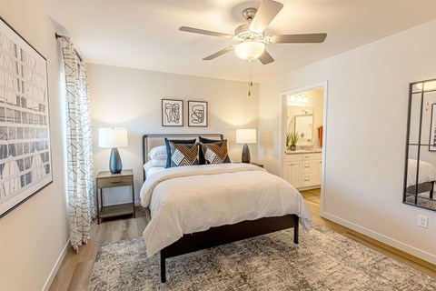 A bedroom with a large bed and a ceiling fan.