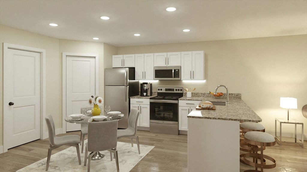 A kitchen with a table and chairs in front of it.