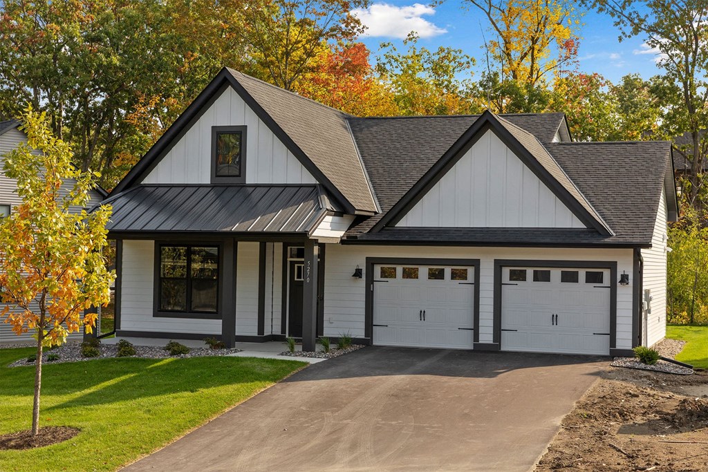 a white house with a driveway and garage doors