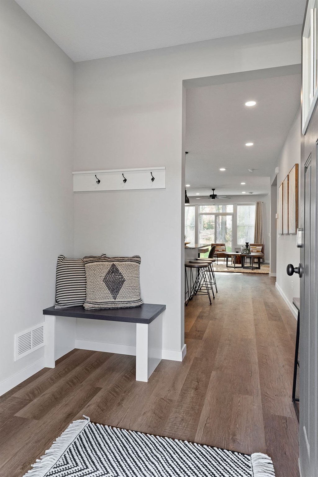 a living room with a couch and a hallway to a dining room