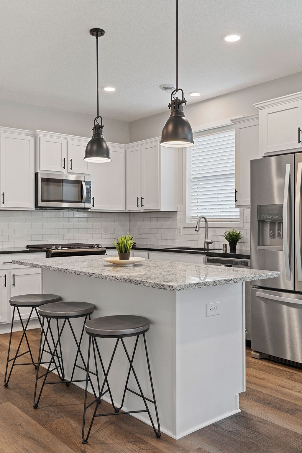 a kitchen with a large island and three bar stools
