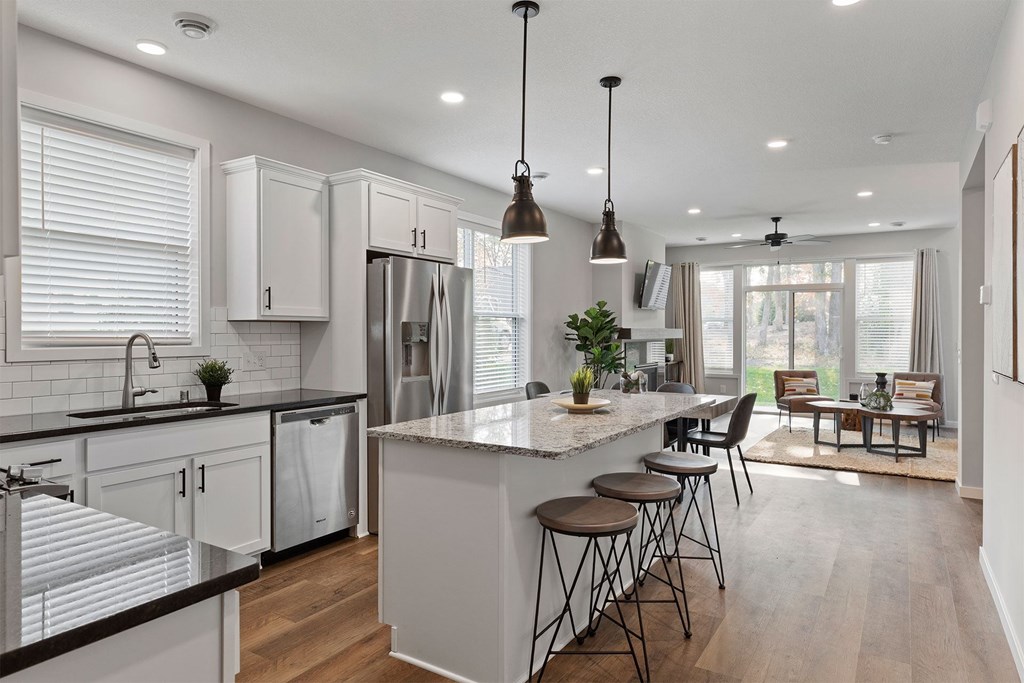 A modern kitchen with a large island and stools.