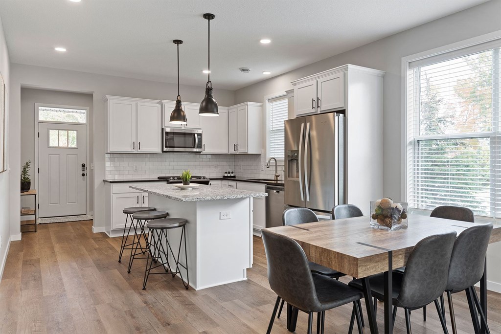 A modern kitchen with a dining table and chairs.
