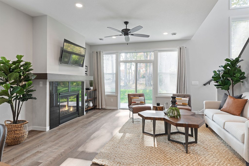 a living room with a fireplace and a ceiling fan