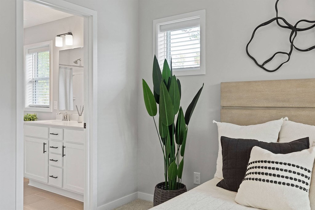 a bedroom with a bed and a bathroom with a sink