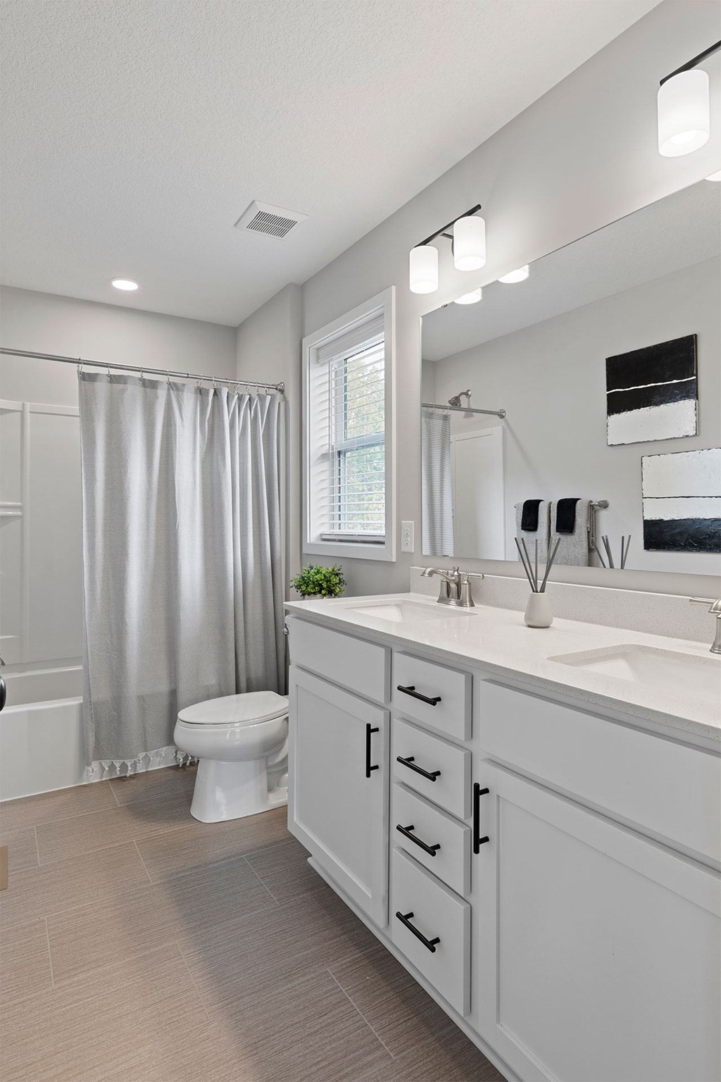 A bathroom with a toilet, sink, and shower.