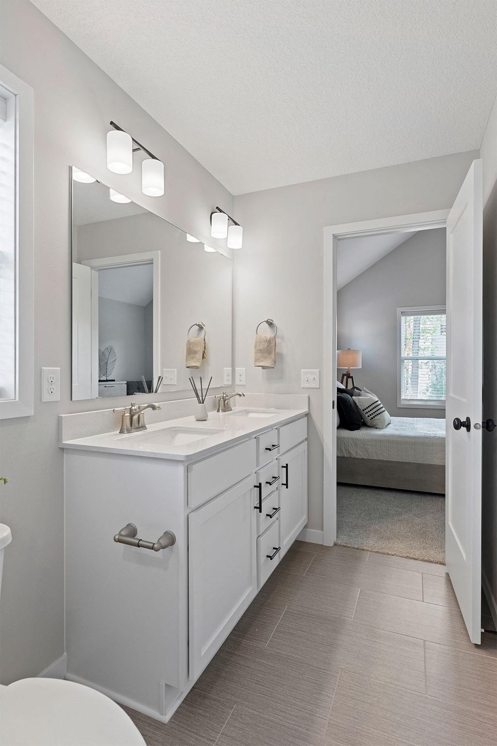 a white bathroom with a large mirror and a sink