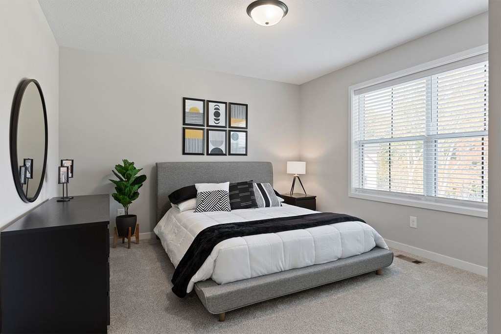 A bedroom with a large bed and a mirror on the wall.