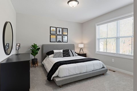 A bedroom with a large bed and a mirror on the wall.