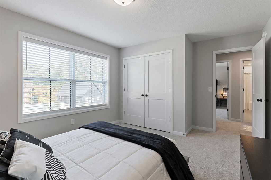 a bedroom with a large window and a bed