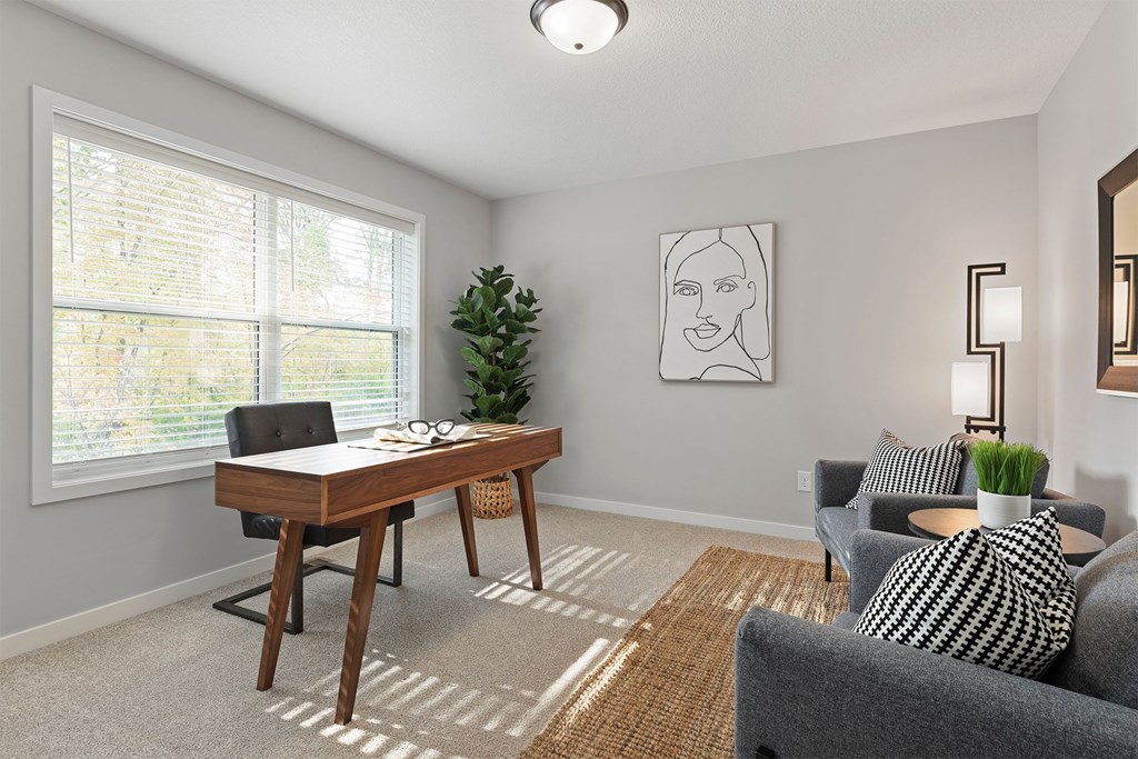 A room with a desk, chair, and couch.