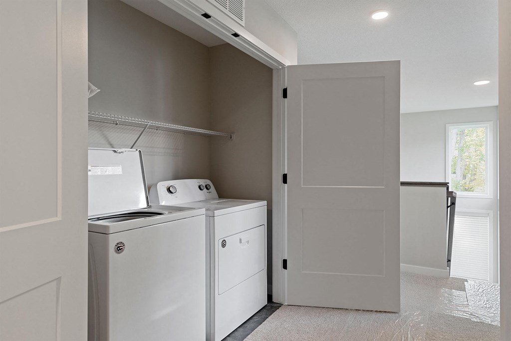 a laundry room with a washer and dryer and a refrigerator