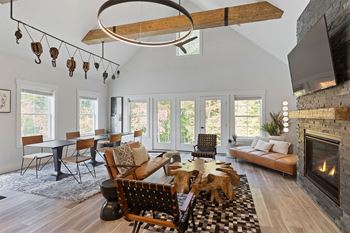 a living room with a fireplace and a table with chairs and a couch