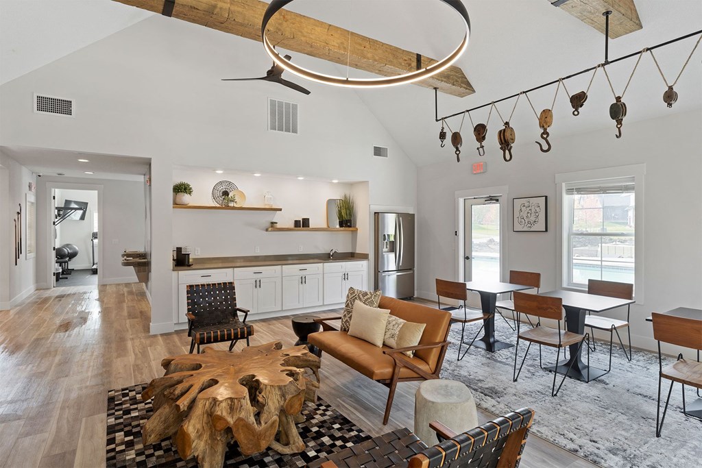 a living room with a couch and chairs and a dining room table and a kitchen