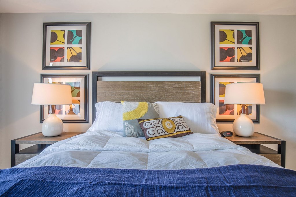 a bedroom with a bed and paintings on the wall
