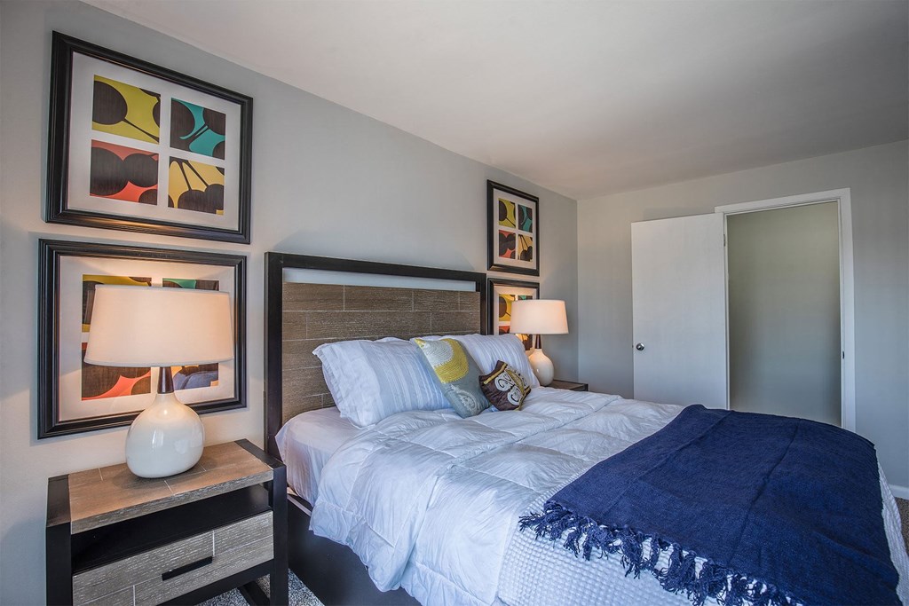 a bedroom with a bed and paintings on the wall