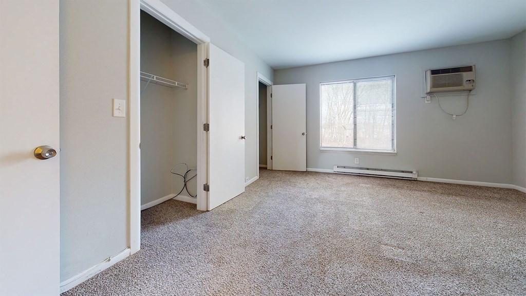 an empty room with a closet and a window