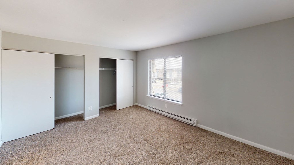 a bedroom with a large window and a closet