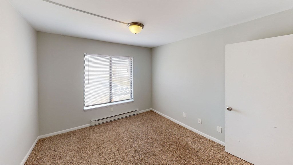 an empty room with a window and a door