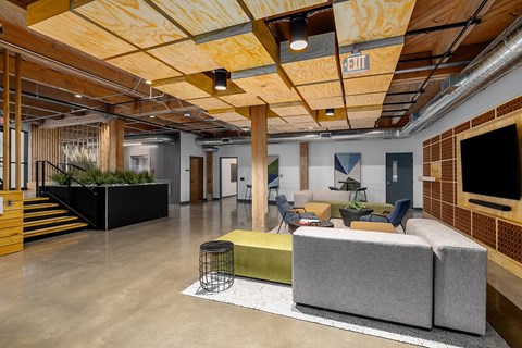 A modern lobby space with a green plant on the stairs.
