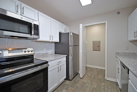 A kitchen with white cabinets and a black stove top oven.