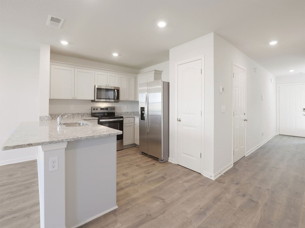 A kitchen with a granite countertop and stainless steel appliances.