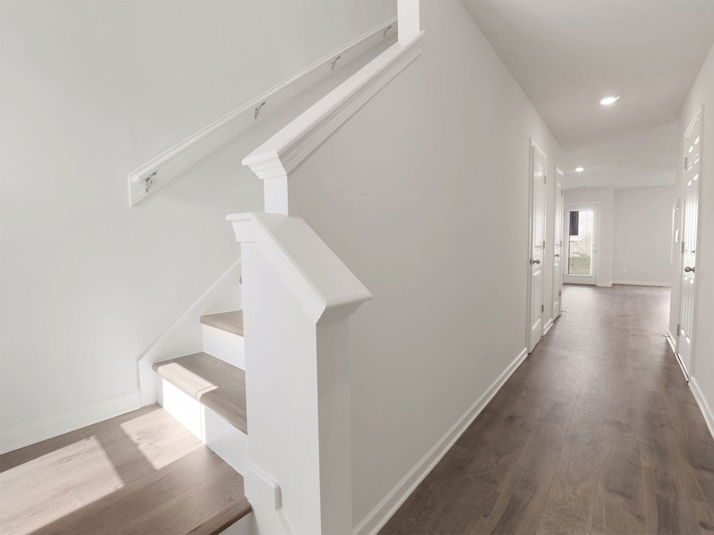 A long hallway with a staircase on the left side.